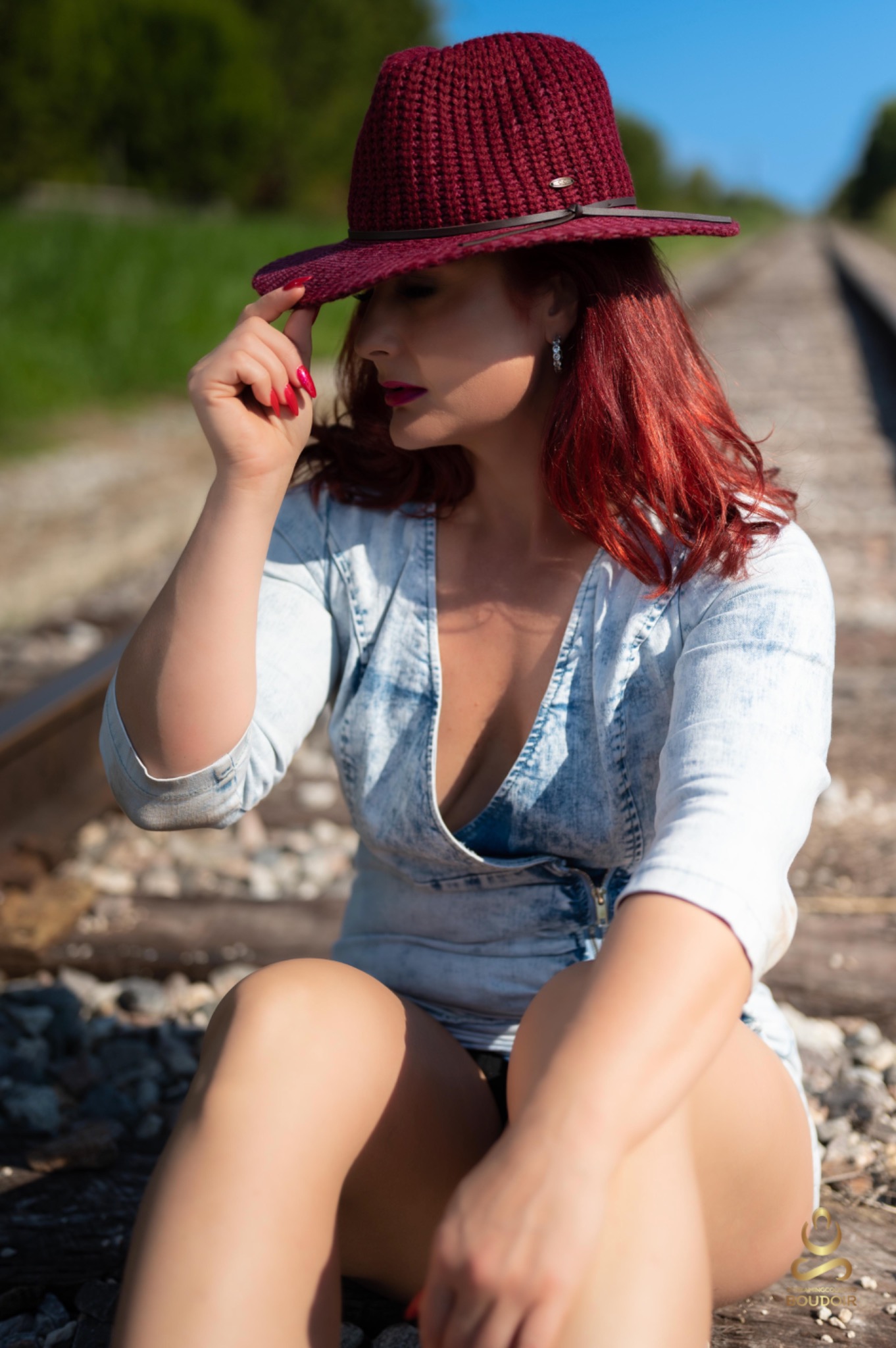 Signature portrait outdoors in a burgundy hat